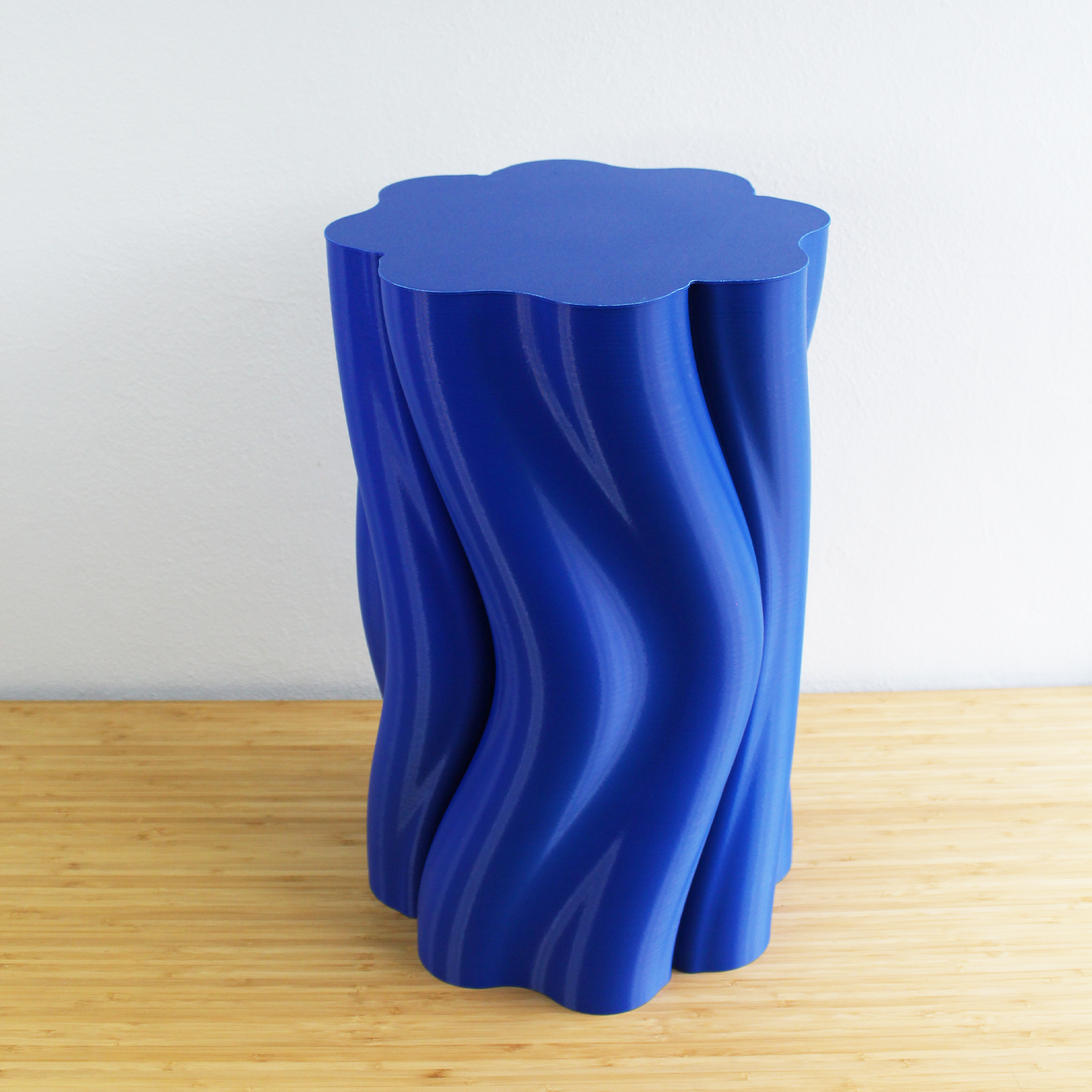 Close-up of blue Dune Side Table showing smooth wave-like texture and elegant curved details.