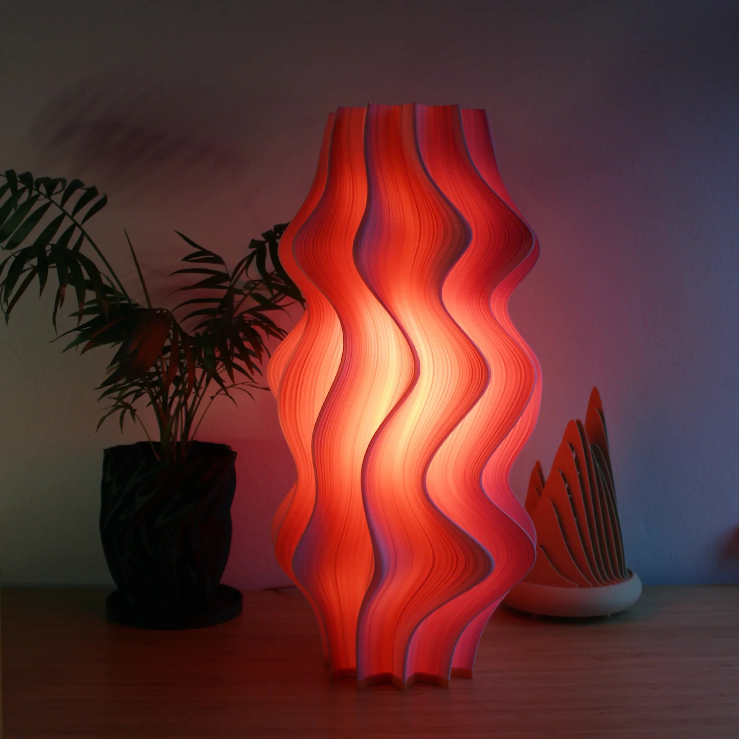 Namami Studio’s statement Iris Lamp in vibrant flamingo shade, glowing warmly in a modern space