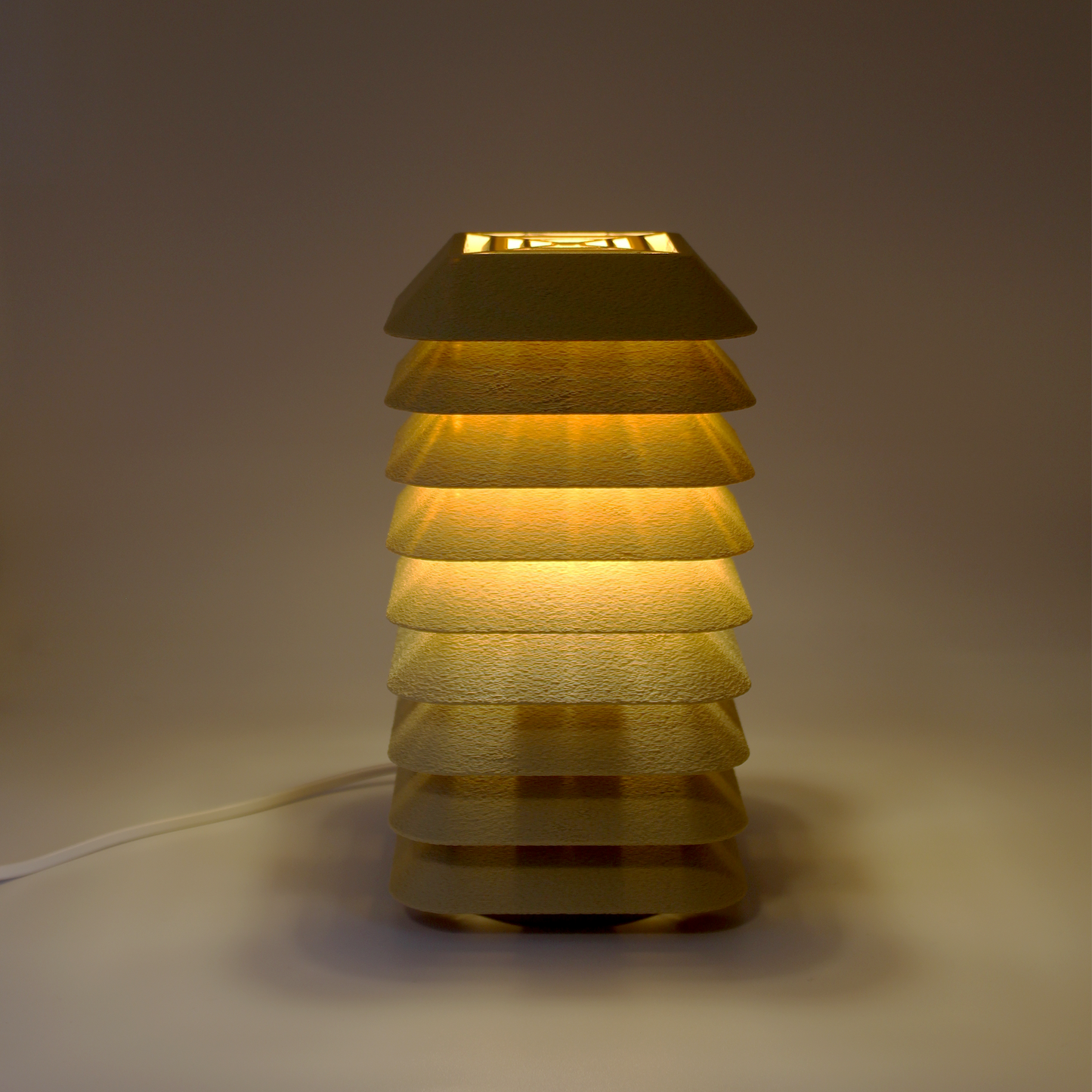 Stacked beige lamp on a neutral background