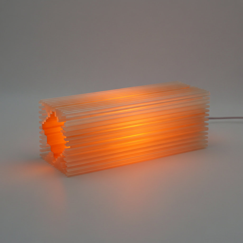 Shard lamp with a ribbed design glowing orange on a neutral background