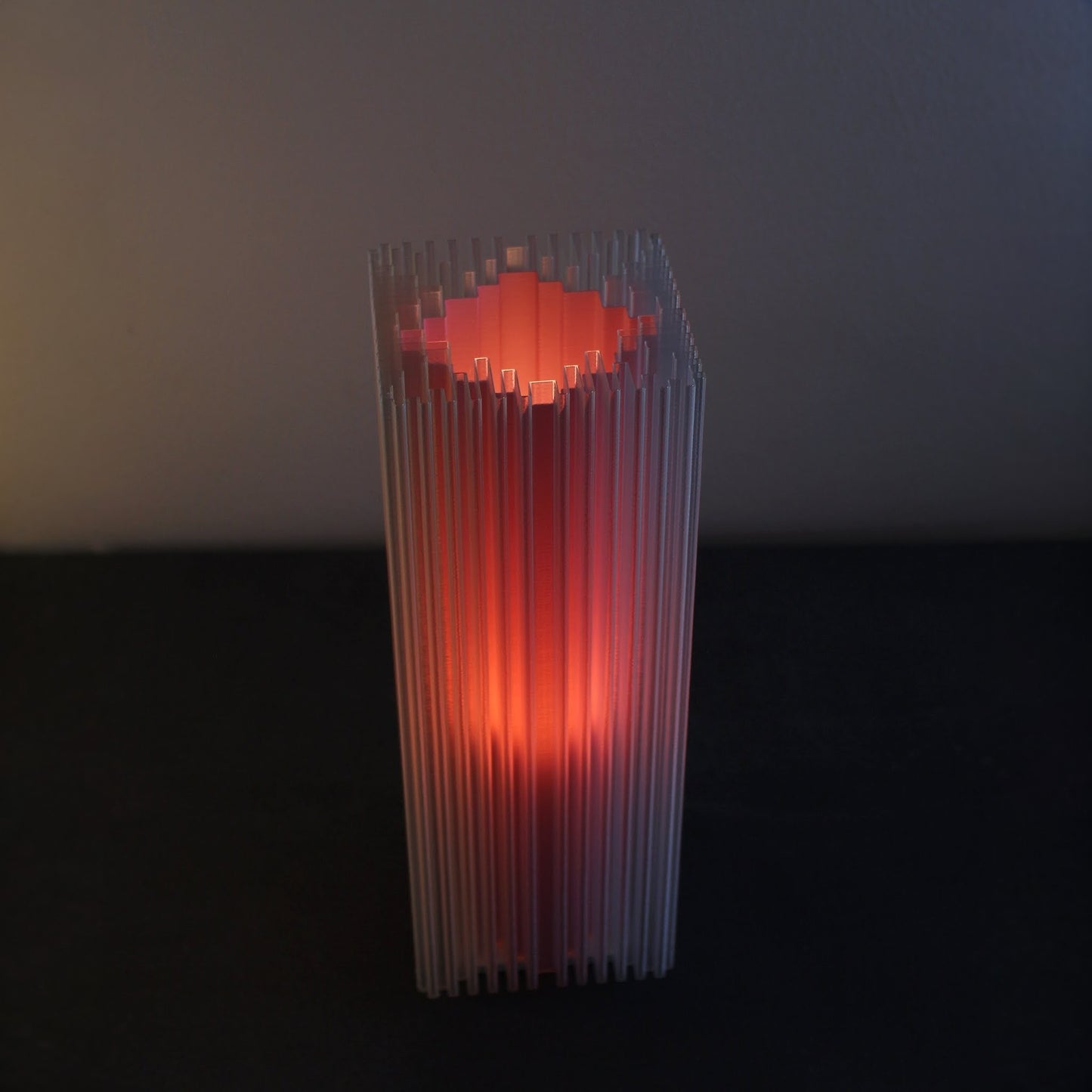 Lamp with shard-inspired vertical texture, soft Flamingo glow radiating through layered ridges.