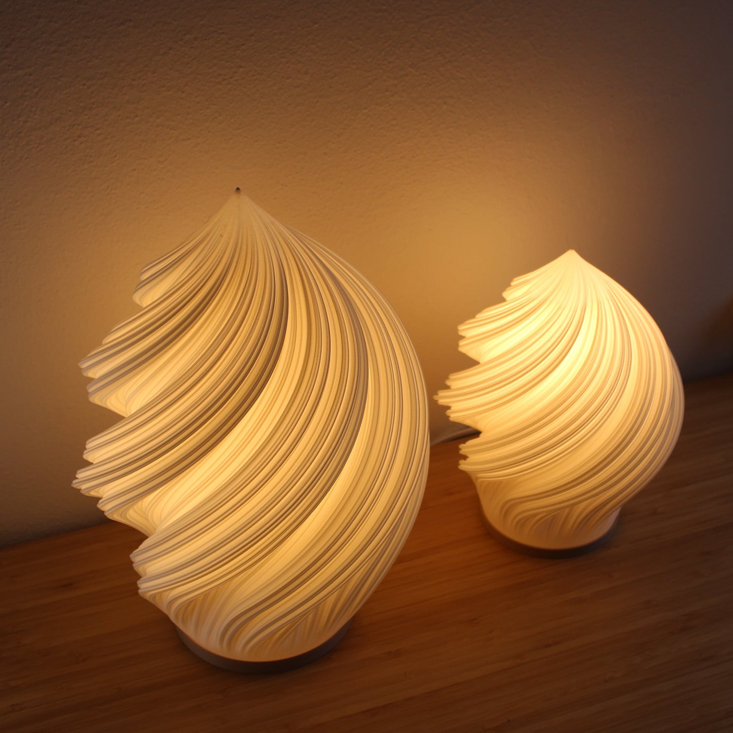 White Soft Serve Lamp illuminated against a neutral background, highlighting its flowing silhouette.