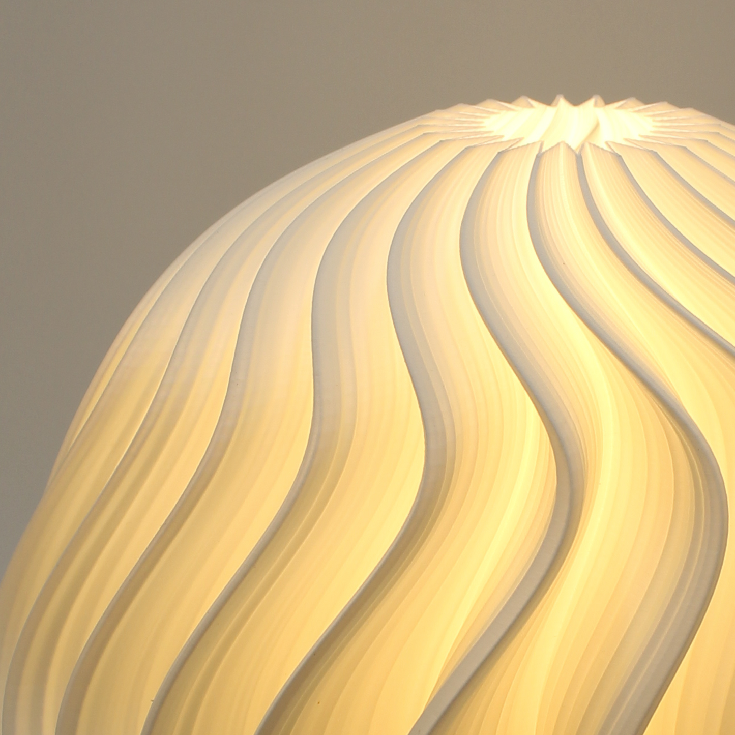 Close-up of a textured iris orb lampshade with wavy pattern on a dark background