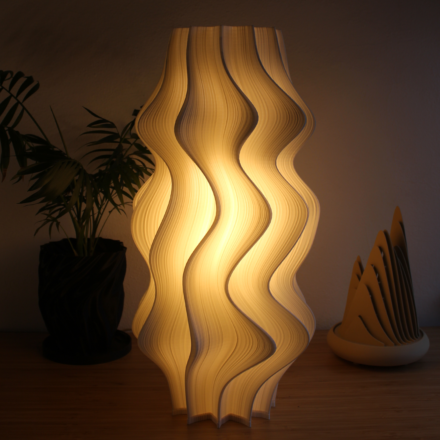 Large white Iris Lamp with sculptural pleated design on display in a minimalist interior.
