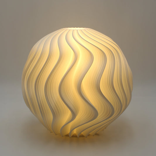 Studio close-up of the White Orb Lamp with its curved wave-like texture illuminated in warm white light.