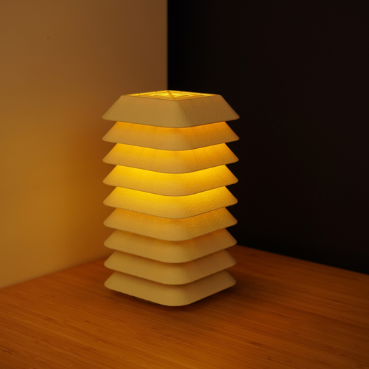 Oat Kengo Tō lamp illuminated with a warm glow