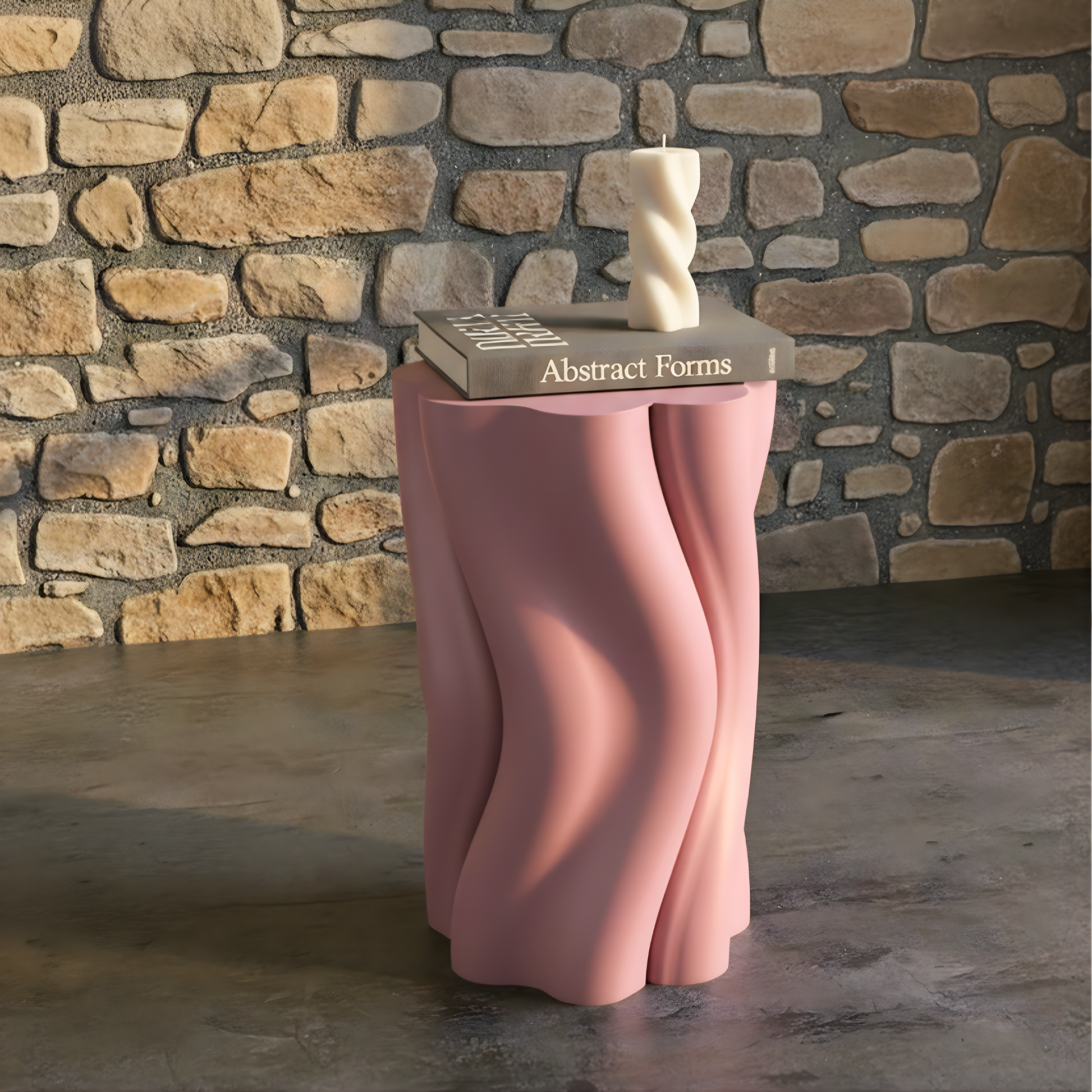 Pink Dune Side Table by Namami Studio with a book titled 'Abstract Forms' and a sculpture against a stone wall.