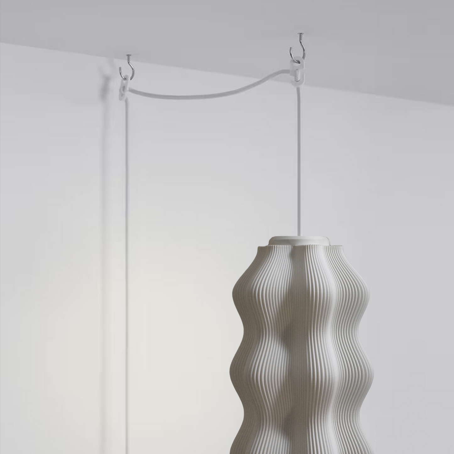Plug-in Harp Pendant Lamp with its cord styled on a wall.