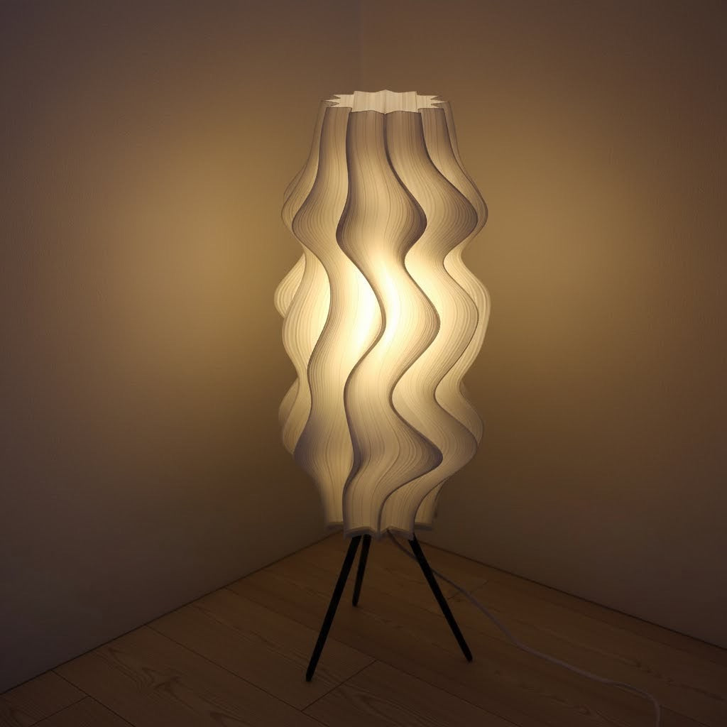 Iris Floor lamp by Namami with wavy design on a tripod base in a dimly lit room.