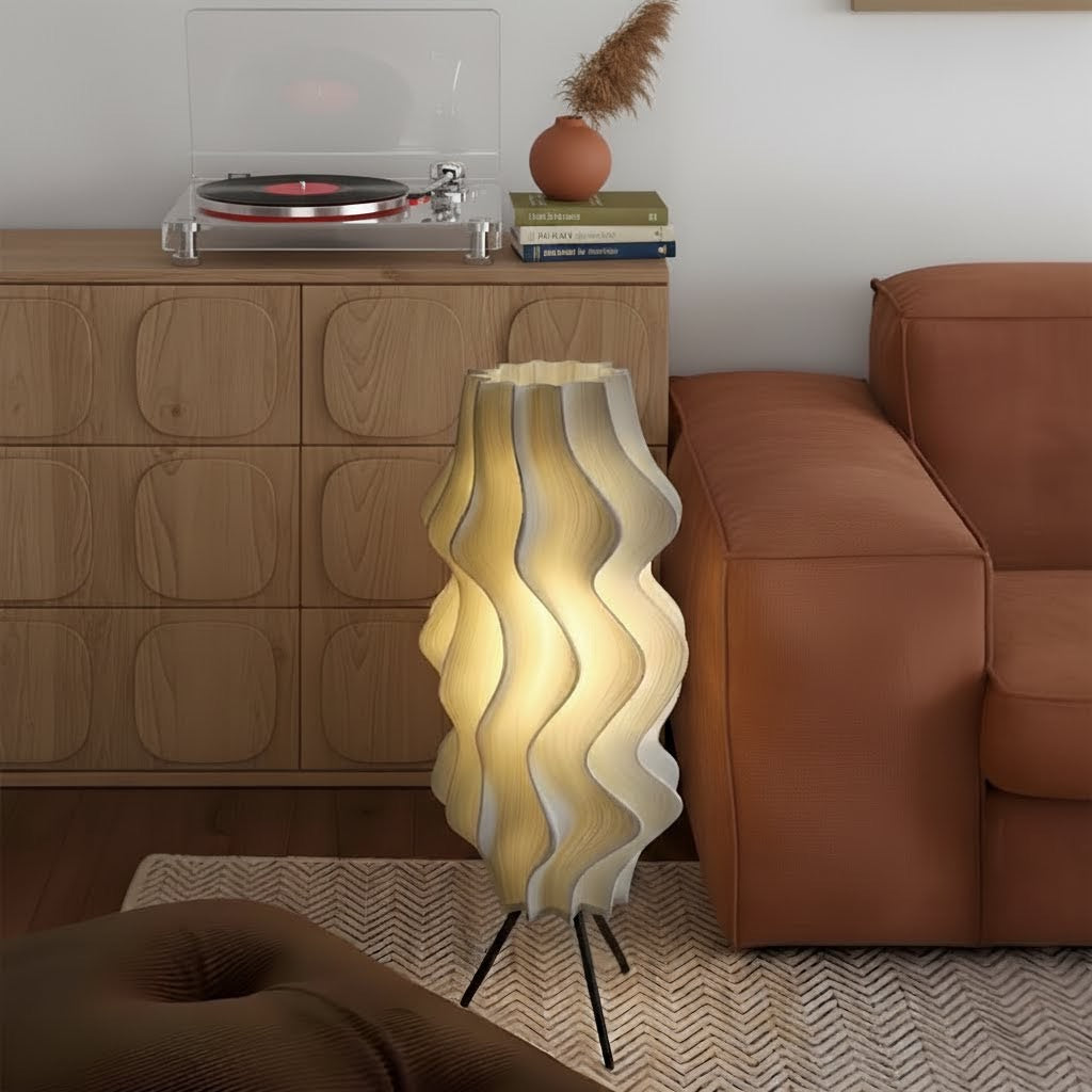 Modern living room with a wavy-patterned Iris floor lamp, brown sofa, and wooden cabinet.