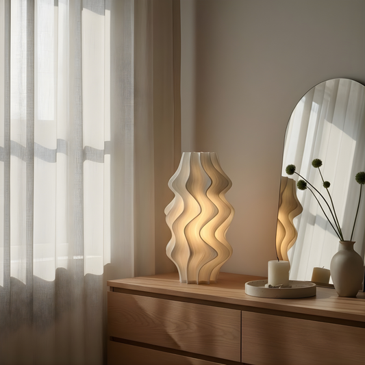 Iris lamp by Namami Studio on a wooden dresser with a mirror and plants in the background