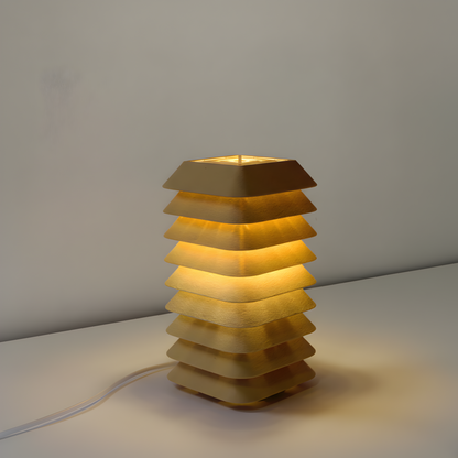 Kengo Tō lamp on a neutral background, highlighting its sculptural tower form and soft illumination.