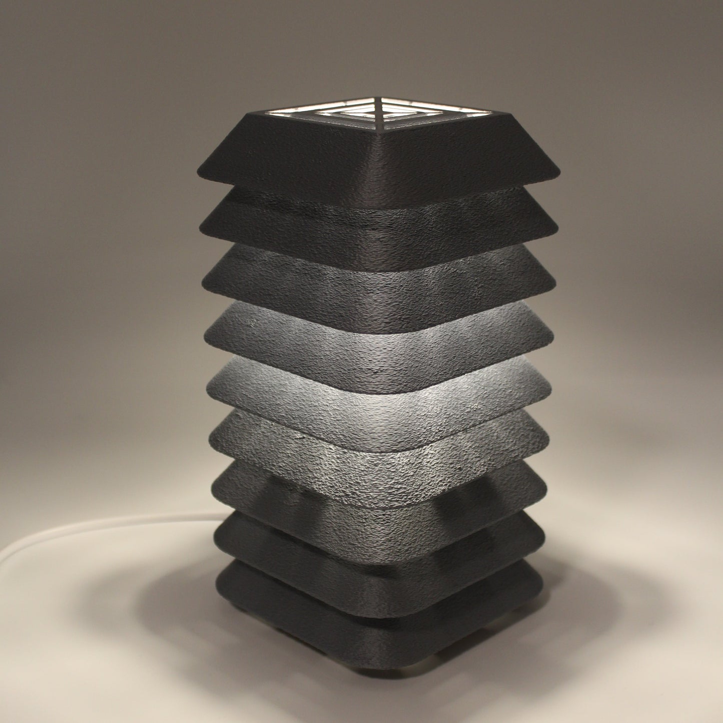 Black textured Kengo To fixture on a neutral background