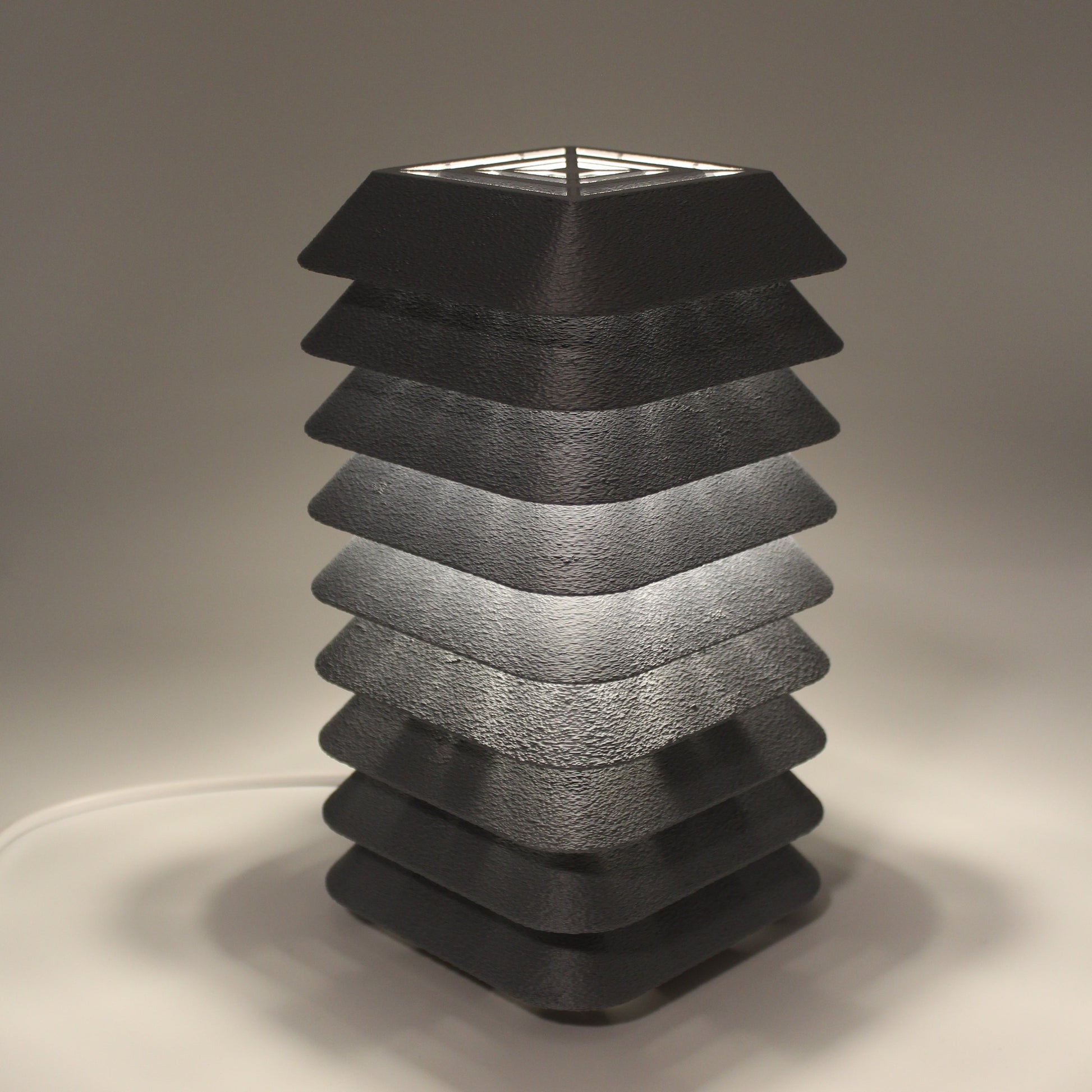 Black textured Kengo To fixture on a neutral background