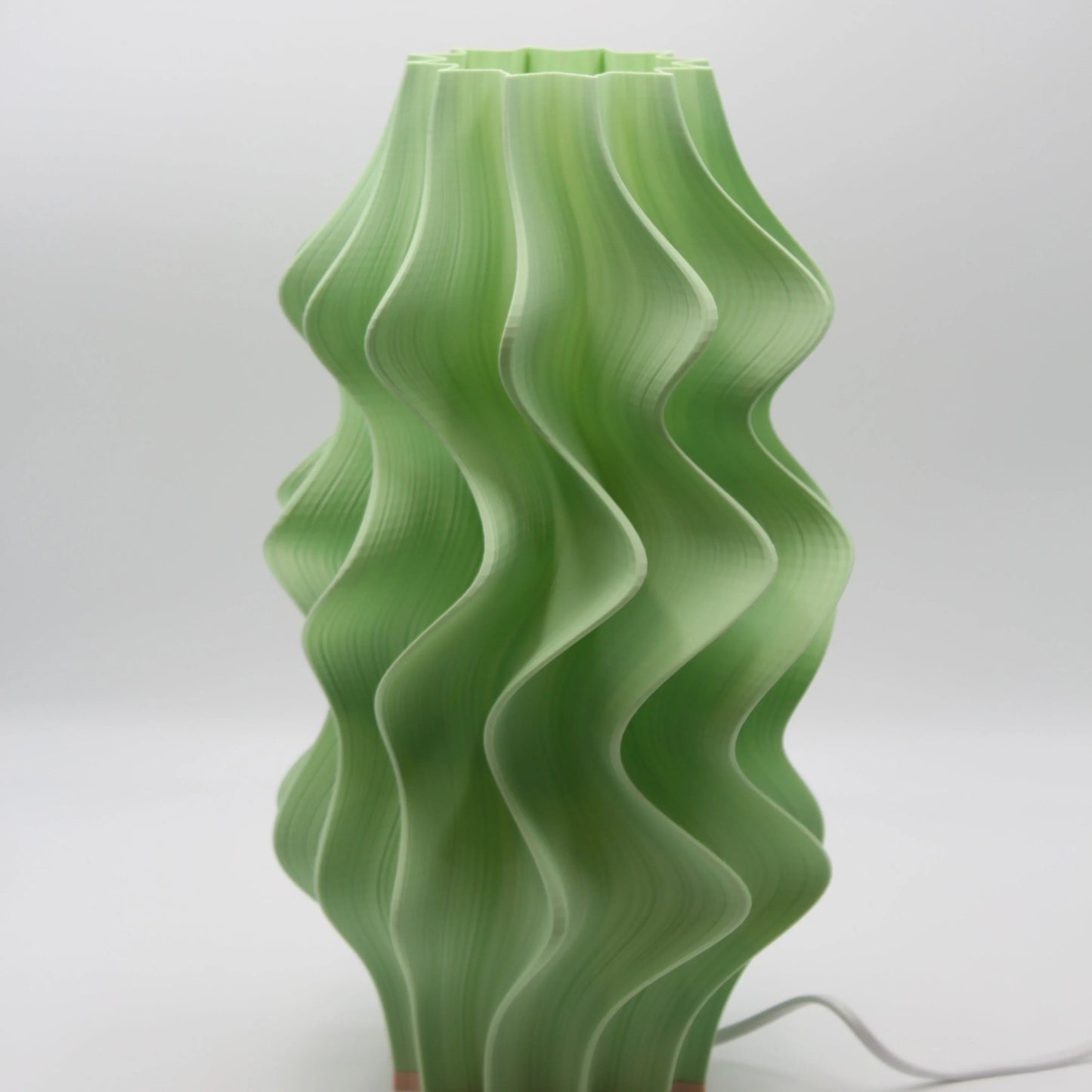 Green wavy Iris Namami lamp on a white background
