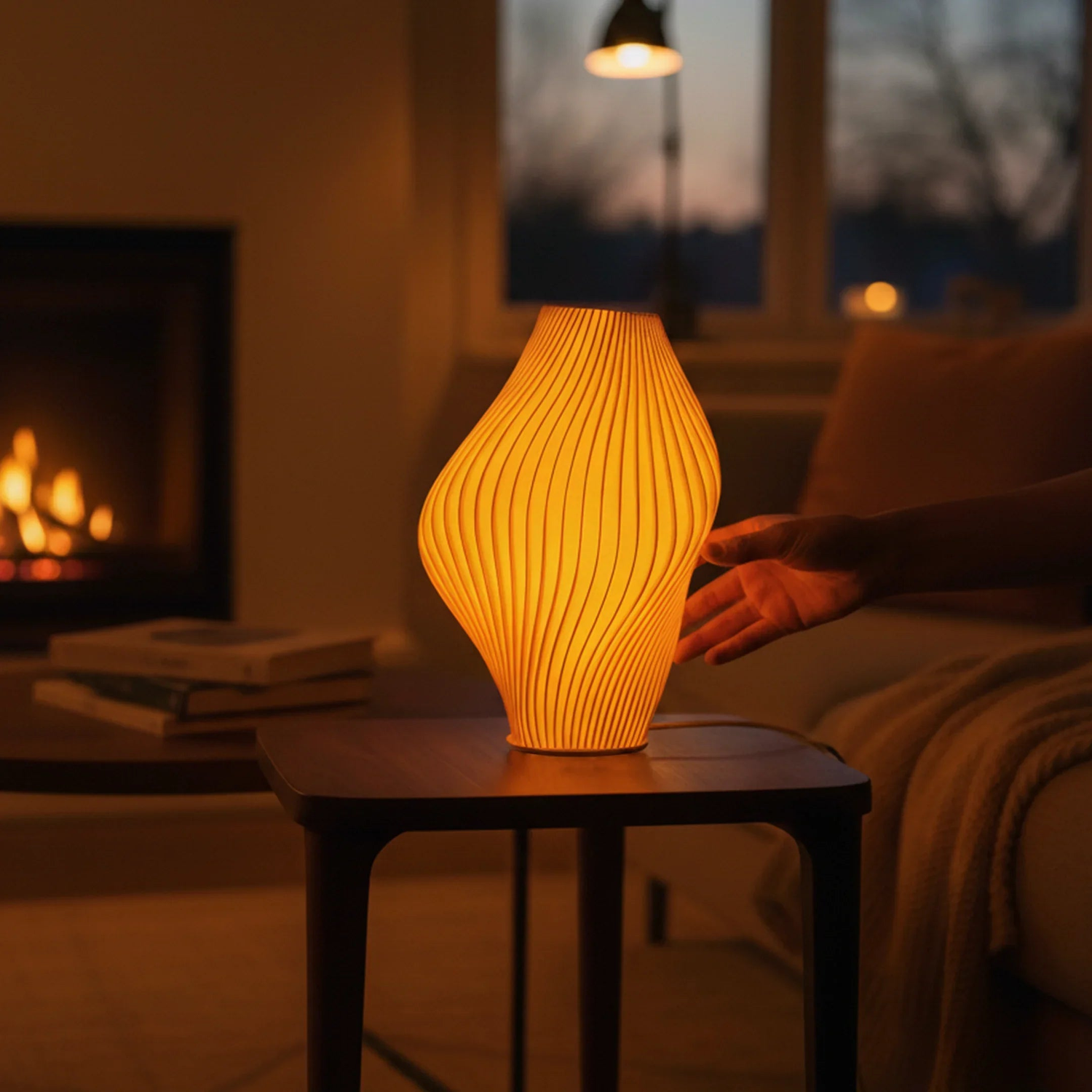 The Namami Studio Mandarin Pleat Lamp glowing softly in a living room at night.