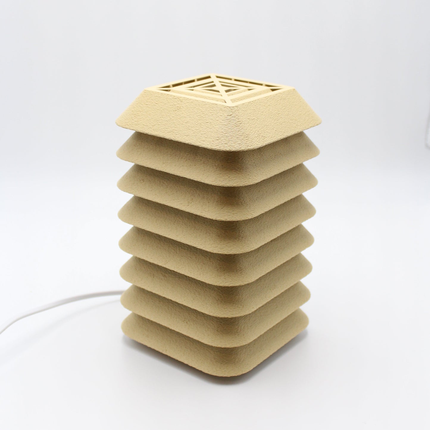 Beige kengo to lamp with geometric design on a white background