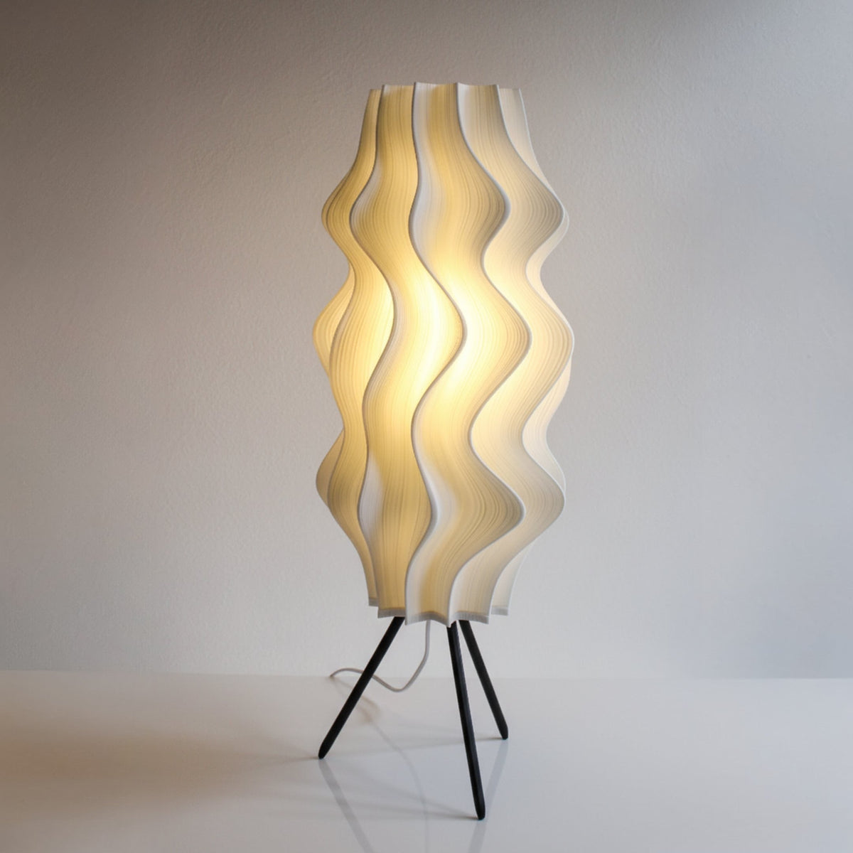 Crème Iris floor lamp illuminated on its detachable tripod stand, design reference for the 66 cm Fragment Edition
