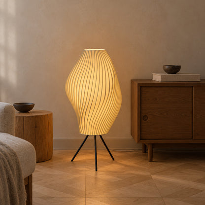 Illuminated Crème Pleat Floor Lamp on black tripod legs in a neutral living room with parquet flooring.