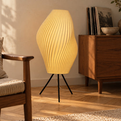 Crème Pleat Floor Lamp glowing beside a timber armchair and walnut cabinet in a sunlit reading corner.