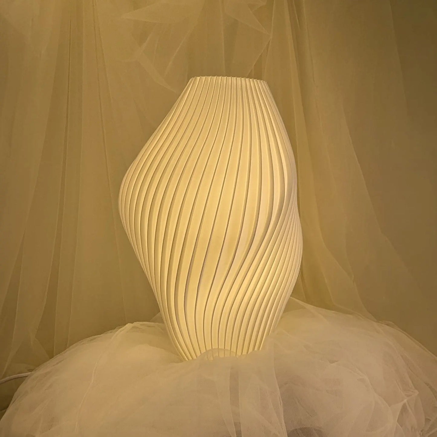 Pleat Lamp Namami, Pleat Lamp glowing softly in curated reading corner